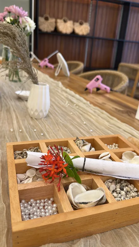 Wooden box filled with shells, pearls and flowers on the workshop table