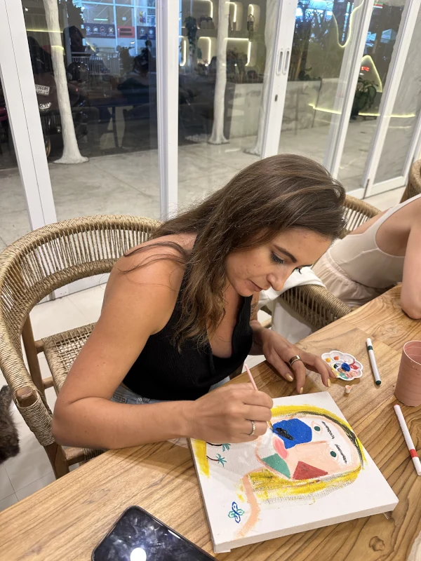 Guest painting a colourful portrait at the Canggu event
