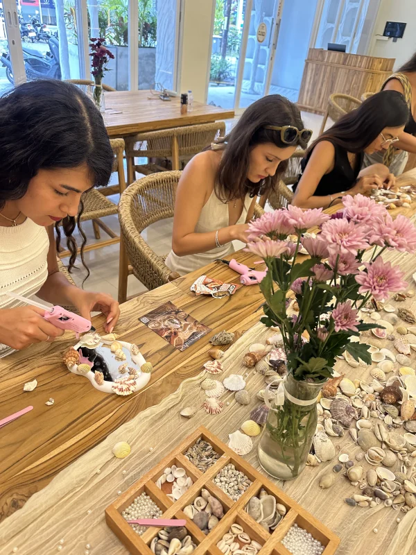 Guests decorating mirrors with shells at the Spanish-language event