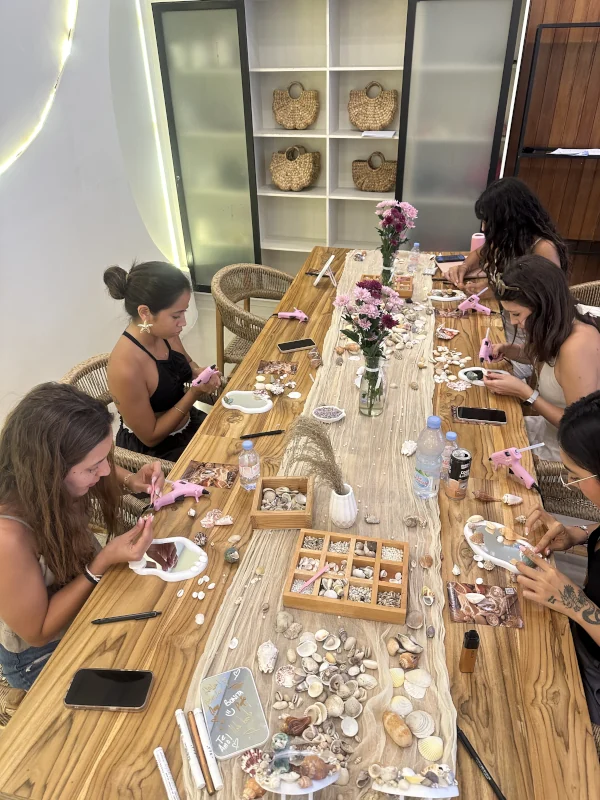 Women making personalised shell mirrors around the Luma Numa studio table