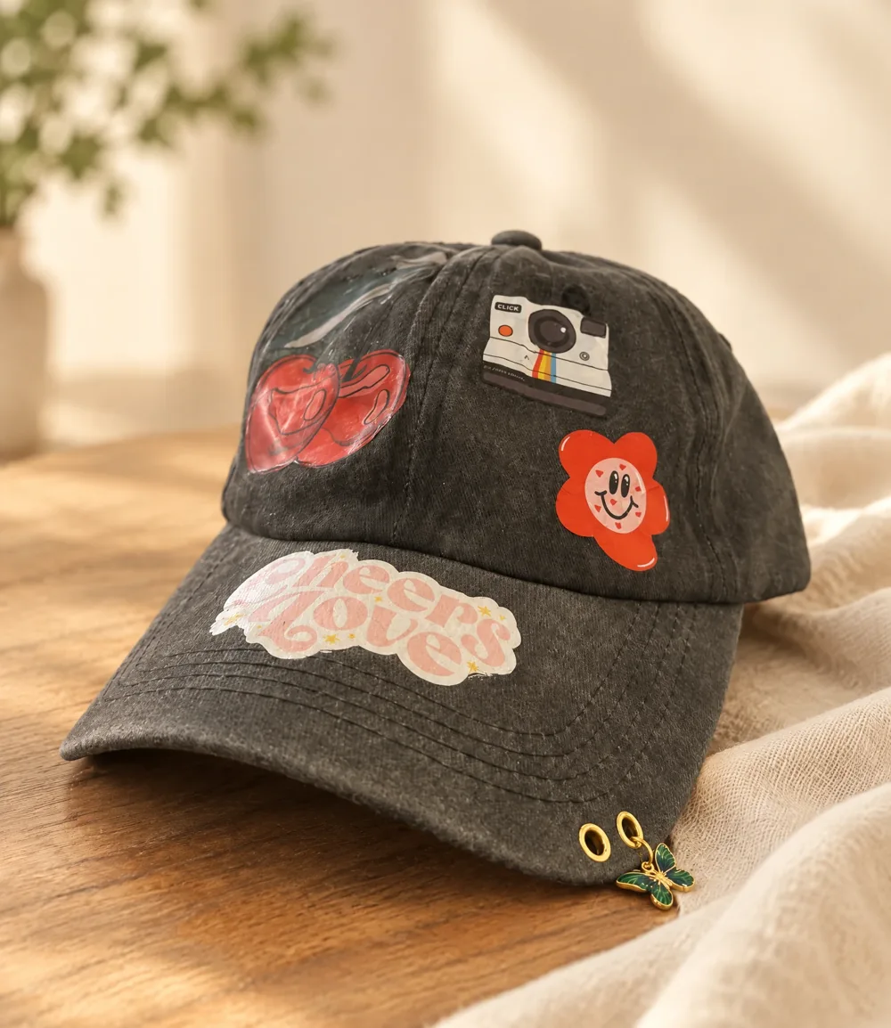 Dark cap personalized with fabric stickers and a charm at Luma Numa