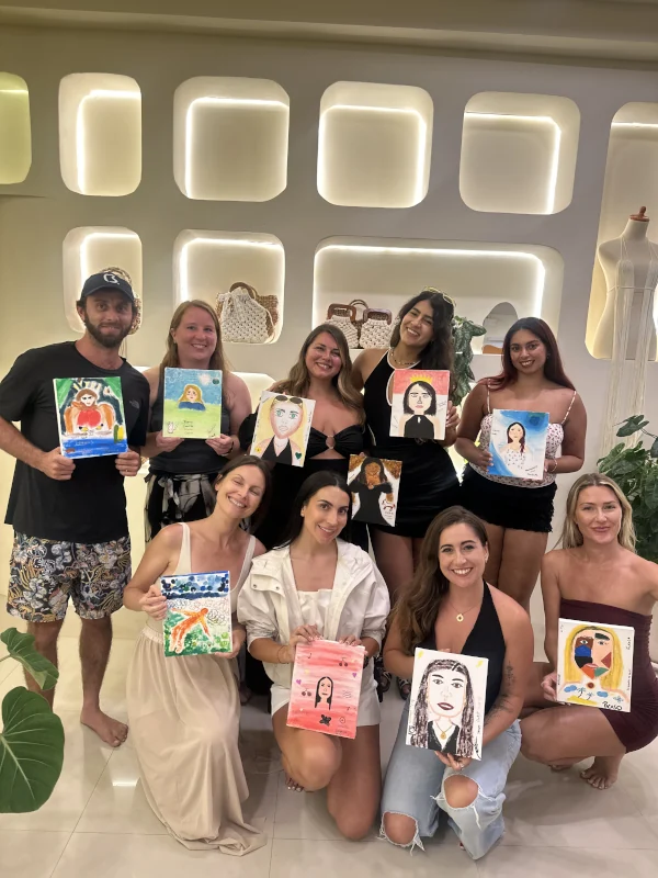 Paint & Strangers guests holding their finished paintings at Luma Numa in Canggu
