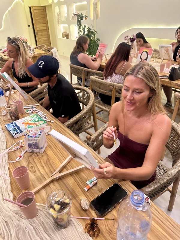 Guests painting together around the studio tables in Canggu